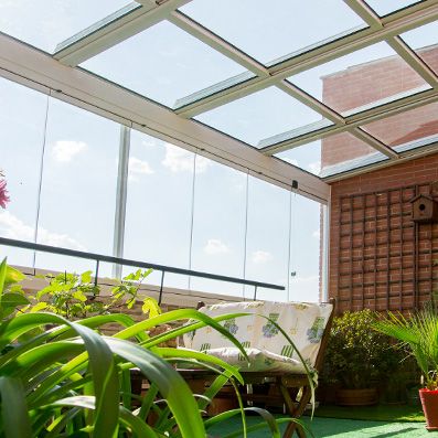 Techo móvil en jardín con zona de estar